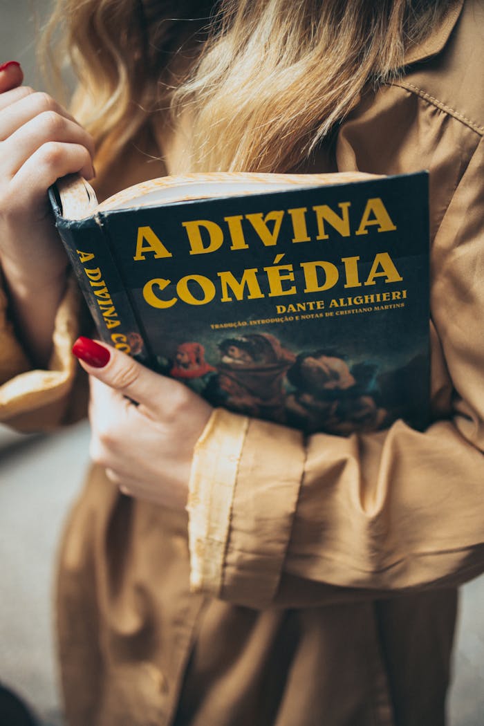 A woman engrossed in reading A Divina Comédia by Dante, showcasing a love for classic literature.